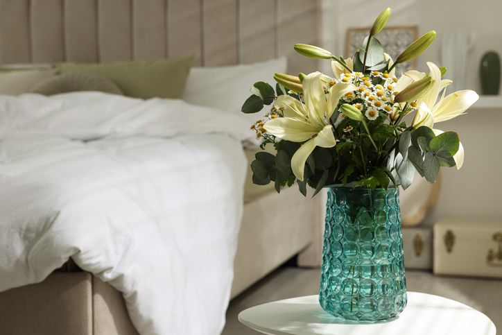 Sumer bedroom interior style - Flower arrangement with double bed in the background